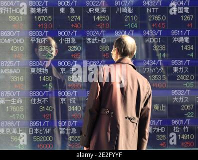 Tokio, Japón. 14 de enero de 2021. Un hombre observa una tabla de precios de acciones en Tokio el jueves, 14 de enero de 2021. Los precios de las acciones japonesas subieron 241.67 yenes para cerrar a 28,698.26 yenes con un nuevo máximo de 30 años en la Bolsa de Tokio. Crédito: Yoshio Tsunoda/AFLO/Alamy Live News Foto de stock
