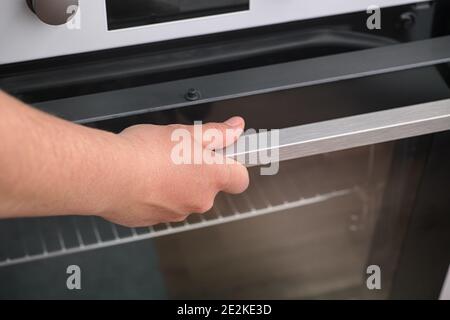 Mujer abriendo un horno. Profundidad de campo reducida. De cerca Fotografía  de stock - Alamy