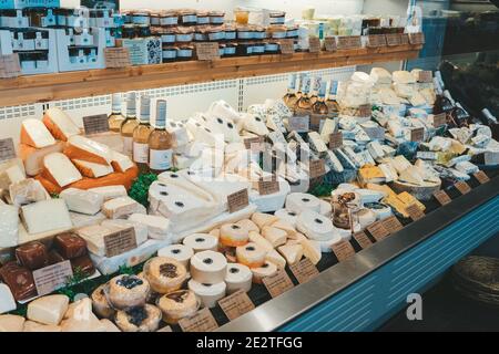 Gouda, países Bajos - 20 de julio de 2020: Muchos tipos diferentes grandes y deliciosas cazas de queso en las estanterías a la venta en una tienda de quesos en Gouda Foto de stock