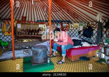 Hombre mongol comiendo dentro de la tradicional ger mongol / yurt, carpa portátil redonda en la estepa de Mongolia Foto de stock
