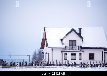 Pułtusk, Polonia - 13 de enero de 2021: Casa unifamiliar y jardín cubierto de nieve. Invierno en el campo. Nieve en el techo. Foto de stock