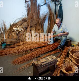 Una cesta weaver en el trabajo en la fábrica tienda en Camacha Madeira Portugal Foto de stock