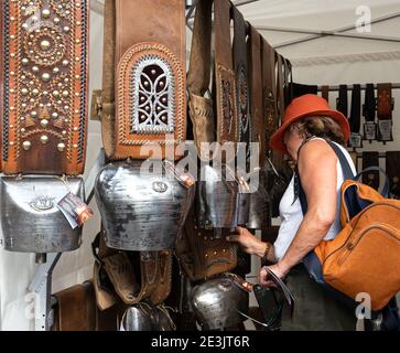 BOURG-SAINT-MAURICE, FRANCIA - 19 DE AGOSTO de 2018: Mujer escogiendo souvenirs de la caseta artesana (de artesano italiano, Aosta) en el tradicional Agricu Foto de stock