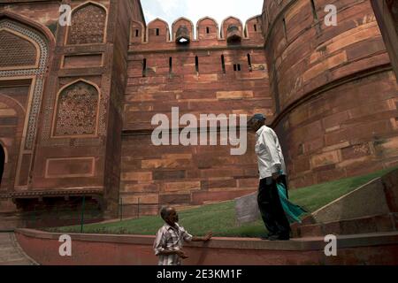 Hombres que tienen conversación en el césped antes de la Puerta Amar Singh de Agra Fort en Agra, Uttar Pradesh, India. Foto de stock