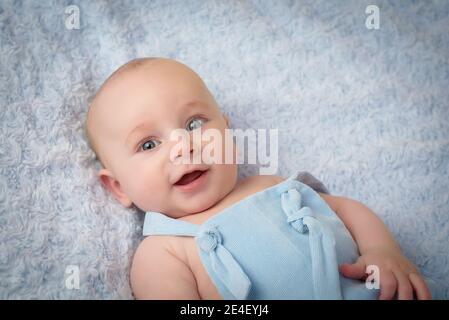 bebé feliz y sonriente con ropa azul en color azul antecedentes