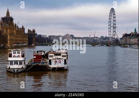 LondonUK - 31 Dic 2020: Vista de barcos en el río Támesis en Londres con las Casas del Parlamento, el Puente de Westminster y el London Eye en el fondo
