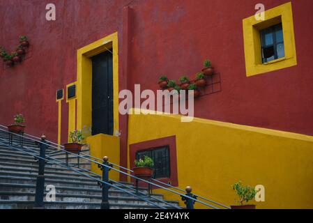 Fachada colonial de la casa con una pared de estuco rojo veneciano, ribete  blanco alrededor de las ventanas y rejillas de hierro artesanales en  Cholula, Puebla México Fotografía de stock - Alamy