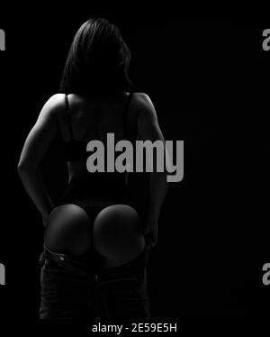 Sexy mujer modelo con el cuerpo perfecto en negro ropa interior soportes  volver a la cámara sacando sus jeans mostrando nalgas Fotografía de stock -  Alamy