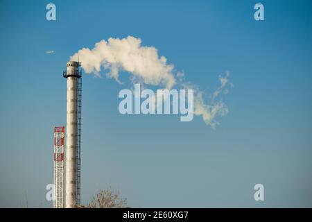Chimenea de humo contra el cielo azul, fondo industrial Foto de stock