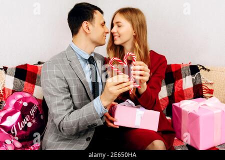 pareja joven en casa sosteniendo un regalo. hombre sorprendiendo a su  esposa con caja de regalo en el día de san valentín. 8 de marzo feliz día  de la mujer 14445471 Foto