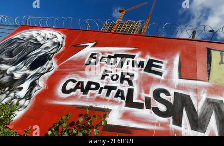 Anti-capitalism graffiti is pictured on a fence surrounding the construction site of the new headquarters of the European Central Bank (ECB) in Frankfurt, September 19, 2012. The ECB will hold a topping out ceremony of the new building with ECB President Mario Draghi on Thursday September 20.   REUTERS/Kai Pfaffenbach (GERMANY - Tags: BUSINESS POLITICS)