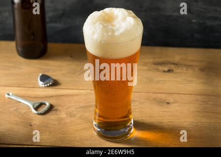 Cerveza de oro en un vaso alto con espuma Foto de stock