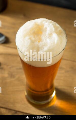 Cerveza de oro en un vaso alto con espuma Foto de stock