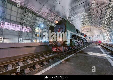 Moscú, Rusia - 30 de enero de 2021: El tren de vapor retro está junto a la plataforma de pasajeros. Foto de stock