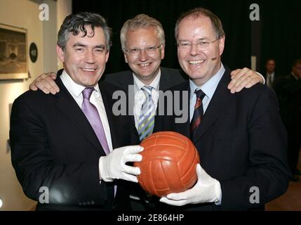 Britain's Chancellor of the Exchequer Gordon Brown (L) holds the original football from England's 1966 World Cup victory with German Finance Minister Peer Steinbrueck and Sweden's Finance Minister Paer Nuder (C) at the Sports and Olympics Museum in Cologne, Germany, June 20, 2006. England are due to play Sweden in the last of their World Cup soccer group stage matches in Cologne tonight.  REUTERS/Peter Macdiarmid/Pool