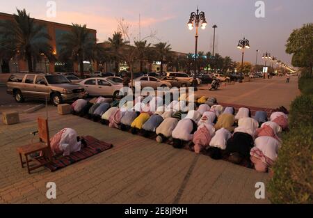 Members of the Committee for the Promotion of Virtue and Prevention of Vice, or religious police, perform dusk prayers with Saudi youth on the street outside coffee shops in Riyadh June 27, 2010. The men conducted the prayers during half-time of the World Cup soccer match between Germany and England, which they had been watching. The police have been ensuring that people watching World Cup soccer matches at the coffee shops continue to conduct their prayers during the duration of the soccer tournament. REUTERS/Fahad Shadeed (SAUDI ARABIA - Tags: SPORT SOCCER WORLD CUP RELIGION)