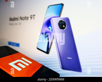 Teléfono con el logotipo de la empresa del fabricante chino de smartphones Xiaomi Corporation en la pantalla frente al sitio web de la empresa. Céntrese en la pantalla del teléfono móvil. Foto de stock