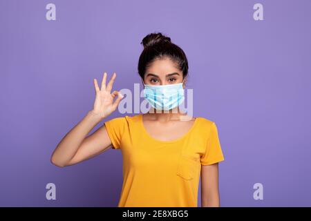 Mujer India en máscara médica mostrando un gesto de signo de ok Foto de stock