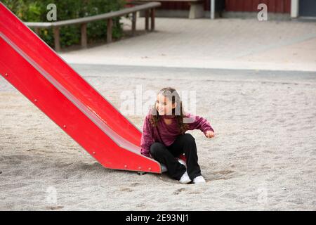 Chica en tobogán en el parque infantil Foto de stock
