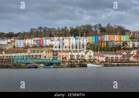 Vista al otro lado del río Avon en Bristol, Inglaterra, hacia modernos apartamentos junto al río, y coloridas casas adosadas antiguas detrás. Foto de stock