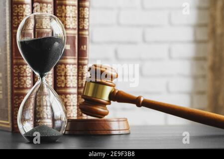 Concepto de tribunal. Reloj de arena y juez gavel en la mesa