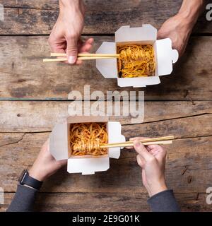 Vista superior de una pareja comiendo comida china de las cajas Foto de stock