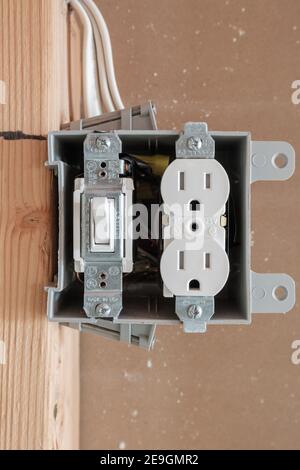 Instalación de caja de enchufe eléctrico y el interruptor de luz dentro de  la pared de yeso Fotografía de stock - Alamy