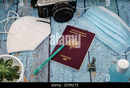 Concepto de turismo de vacunas Covid. Vista superior de un pasaporte y una jeringa en una mesa azul. Foto de stock