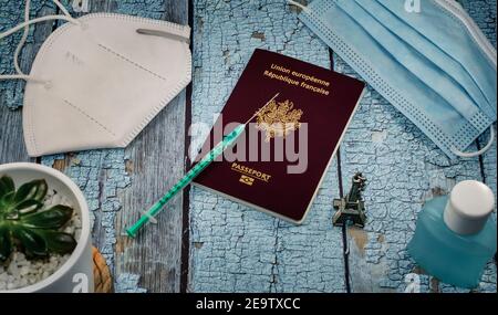 Concepto de turismo de vacunas Covid. Vista superior de un pasaporte y una jeringa en una mesa azul. Foto de stock