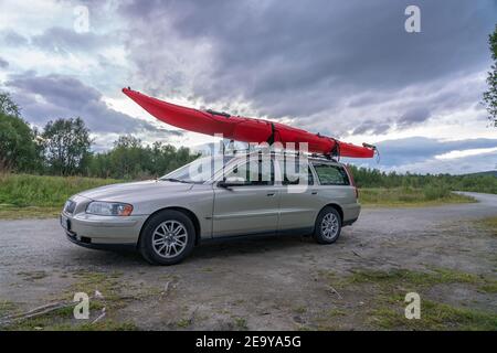 Joesjo, Suecia 21 DE AGOSTO de 2020: Ir en kayak: Largo kayak de mar rojo montado en el techo de color verde claro coche. Día de verano, vacaciones de viaje Foto de stock