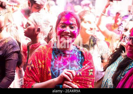 Jodhpur, rajastha, india - 20 de marzo de 2020: Mujer india joven celebrando el festival de holi, cara cubierta con polvo de colores. Foto de stock