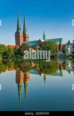 Torres inclinadas de la Catedral reflejadas por el agua del lago Mühlenteich en Lübeck en Schleswig-Holstein, Alemania Foto de stock