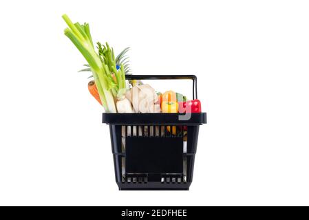 Cesta de compras de plástico negro llena de comestibles y verduras aisladas sobre fondo blanco Foto de stock