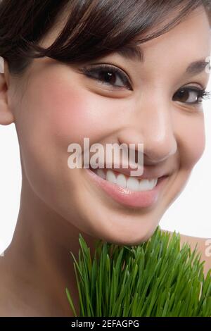 Primer plano de una mujer joven con hierba de trigo Foto de stock