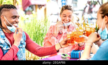 Los jóvenes beben en el bar de cócteles con máscara abierta - Nuevo concepto normal de amistad con amigos felices divirtiéndose tostar juntos bebidas