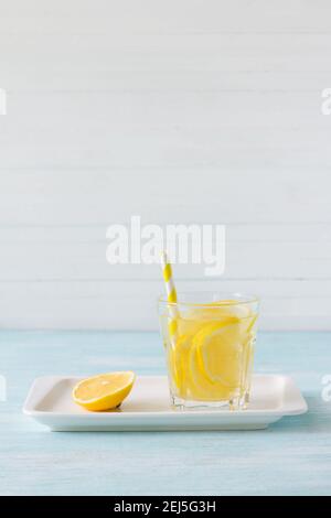 Agua de limón en un vaso sobre fondo blanco. Enfoque selectivo. Bebida saludable por la mañana Foto de stock