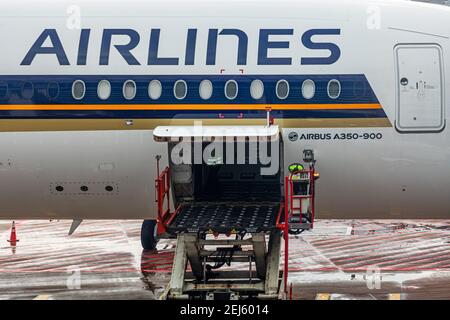 Un cargador ULD para dispositivos de carga de unidades de elevación (ULD) a. La bahía de carga de una aeronave de una máquina de Singapore Airlines y. Un transportista ULD en el aeropuerto Changi