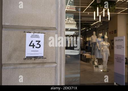 Vista de un cartel en la puerta de la tienda de ropa Stradivarius que  indica el número de clientes permitidos durante la fase  del   pequeña y mediana empresa minorista de