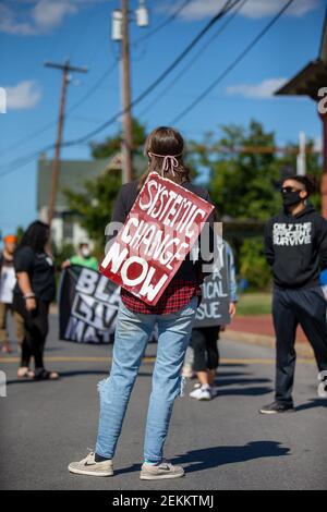 Un manifestante Black Lives Matter lleva un signo que dice "cambio sistémico ahora" en un mitin fuera de la comisaría de policía en Milton, Pennsylvania el 20 de septiembre de 2020. (Foto de Paul Weaver/Sipa USA)