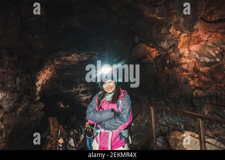 Mujer viajero explorar túnel de lava en Islandia. Raufarholshellir es un hermoso mundo escondido de cueva. Es una de las lava más largas y más conocidas