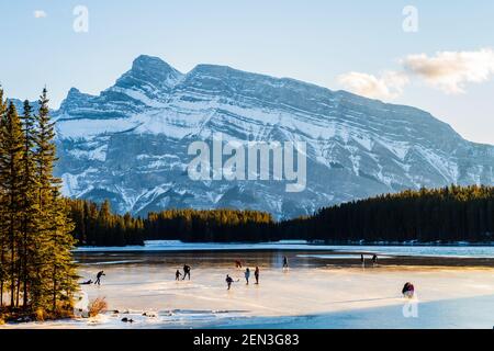 Hermosa vista de la gente patinando sobre hielo en los dos Jack Lake en el Parque Nacional Banff, Canadá