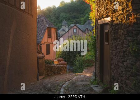 Un carril de campo en el pintoresco y encantador pueblo medieval francés de Conques, Aveyron, un popular destino turístico de verano en la región de Occitanie Foto de stock