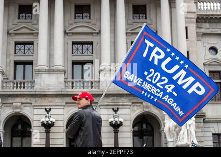 Harrisburg, Estados Unidos. 27 de febrero de 2021. Un manifestante tiene una bandera de Trump 2024 frente al Capitolio del Estado de Pensilvania.alrededor de 40 personas se reunieron en los escalones del Capitolio del Estado de Pensilvania para la manifestación de la "1ª Enmienda": Los conservadores son censurados. Crédito: SOPA Images Limited/Alamy Live News Foto de stock