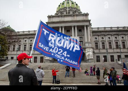 Harrisburg, Estados Unidos. 27 de febrero de 2021. Un manifestante tiene una bandera de Trump 2024 frente al Capitolio del Estado de Pensilvania.alrededor de 40 personas se reunieron en los escalones del Capitolio del Estado de Pensilvania para la manifestación de la "1ª Enmienda": Los conservadores son censurados. Crédito: SOPA Images Limited/Alamy Live News Foto de stock