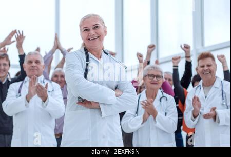 un grupo de médicos y pacientes recuperados celebran la victoria Foto de stock