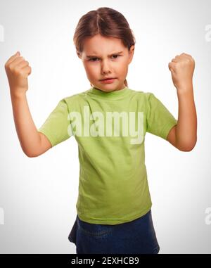 Enojado niño niña muestra mal los puños experimentando ira emociones Foto de stock