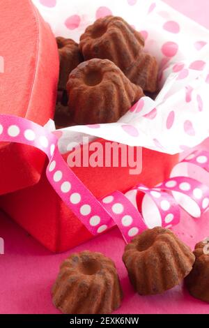 Chocolates pequeños en caja de corazón Foto de stock