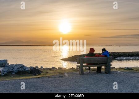 La gente disfruta del paisaje de puesta de sol en Garry Point Park. Richmond, BC, Canadá.