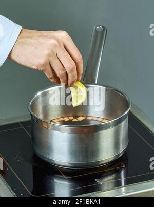 El cocinero sips los ingredientes en una cacerola para cocinar vino caliente lleno de recetas culinarias Foto de stock