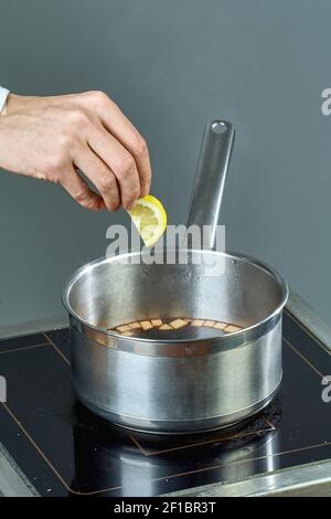 El cocinero sips los ingredientes en una cacerola para cocinar vino caliente lleno de recetas culinarias Foto de stock